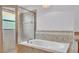 Luxurious bathroom featuring a soaking tub, tiled surround, and glass-enclosed shower at 1765 Kingsmill Dr, Bartow, FL 33830