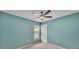 A blue room with a ceiling fan, a window, and a closet with a white door at 1765 Kingsmill Dr, Bartow, FL 33830