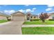 Inviting home showcasing a manicured lawn, stone details, and an attached two-car garage at 1765 Kingsmill Dr, Bartow, FL 33830