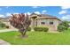Attractive home featuring a well-kept lawn, colorful tree, and stone accents around the bay window at 1765 Kingsmill Dr, Bartow, FL 33830