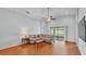Bright living room featuring vaulted ceiling, ceiling fan, wood flooring, and sliding glass doors at 1765 Kingsmill Dr, Bartow, FL 33830