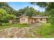 A home's backyard has mature trees, grass, and a small patio area at 1810 Roanoke Ave, Lakeland, FL 33803