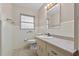 Bathroom with a single sink vanity, white tile, toilet, and a mirror above the sink at 1810 Roanoke Ave, Lakeland, FL 33803