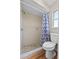 Full bathroom with a shower featuring neutral-toned tiles, a toilet, and wood-look flooring at 1810 Roanoke Ave, Lakeland, FL 33803
