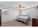 Bedroom with a ceiling fan, two windows, carpet flooring, and a bed with blue pillows at 1810 Roanoke Ave, Lakeland, FL 33803