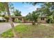 Charming single-story home featuring a covered parking area and mature landscaping at 1810 Roanoke Ave, Lakeland, FL 33803