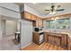 Bright kitchen with wooden cabinetry, a ceiling fan, and a view of the dining area at 1810 Roanoke Ave, Lakeland, FL 33803