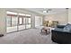 Carpeted living room showcasing sliding doors that open up to a sunroom at 1810 Roanoke Ave, Lakeland, FL 33803