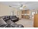 Cozy living room with a dark leather sofa, ceiling fan, and a kitchen bar area at 1810 Roanoke Ave, Lakeland, FL 33803