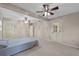 Large main bedroom featuring neutral carpet, dual ceiling fans and exterior door at 1810 Roanoke Ave, Lakeland, FL 33803