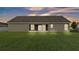 Stucco exterior, screened lanai, and a lush, green lawn at dusk at 204 Walkers Point Dr, Auburndale, FL 33823