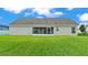 Rear view of the home showing the stucco exterior, screened lanai, and spacious backyard at 204 Walkers Point Dr, Auburndale, FL 33823