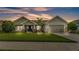 Beautiful single-story home featuring a landscaped yard, a cozy front porch with chairs, and an attached garage at 204 Walkers Point Dr, Auburndale, FL 33823
