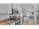 Bright kitchen featuring stainless steel appliances, white cabinetry and stone countertops at 204 Walkers Point Dr, Auburndale, FL 33823
