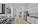 Bright kitchen featuring stainless steel appliances, white cabinetry and stone countertops at 204 Walkers Point Dr, Auburndale, FL 33823