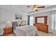 Main bedroom with a tray ceiling, ceiling fan and wooden dresser at 204 Walkers Point Dr, Auburndale, FL 33823