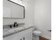 Bathroom with granite countertop vanity, white cabinets, and a modern mirror at 2052 W Elliott St, Lakeland, FL 33805