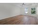 Sunlit bedroom boasts wood flooring, a modern ceiling fan, and bright double windows at 2052 W Elliott St, Lakeland, FL 33805