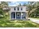Charming two-story home featuring a blue exterior, white trim, covered porch, and a well-maintained lawn at 2052 W Elliott St, Lakeland, FL 33805