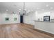 Open-concept living room and kitchen with hardwood floors, white walls, and modern lighting fixtures at 2052 W Elliott St, Lakeland, FL 33805
