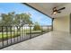 Balcony with view of the trees features dark metal railings and light colored tile at 208 Lake Howard Nw Dr # 104, Winter Haven, FL 33880