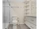 Modern bathroom with glass-enclosed shower and floating shelves for ample storage and clean design at 208 Lake Howard Nw Dr # 104, Winter Haven, FL 33880