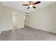 Bedroom features tile floors, ceiling fan, and access to the bathroom and hall at 208 Lake Howard Nw Dr # 104, Winter Haven, FL 33880