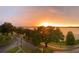 A gorgeous sunrise illuminates a vast lake, framed by mature trees, creating a serene vista at 208 Lake Howard Nw Dr # 104, Winter Haven, FL 33880