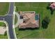 A bird's eye view of a luxury home with a screened in pool, circular driveway and well-maintained landscaping at 209 Pine Lilly Ct, Lake Alfred, FL 33850