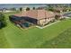 Aerial view of a single Gathering home featuring a screened in pool, manicured lawn, and lush landscaping at 209 Pine Lilly Ct, Lake Alfred, FL 33850