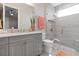 The remodeled bathroom has a walk-in shower with glass door, light gray countertops, and neutral tile at 209 Pine Lilly Ct, Lake Alfred, FL 33850