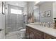 The modern bathroom features a walk-in shower with neutral tile, and a dark wood vanity with a marble top at 209 Pine Lilly Ct, Lake Alfred, FL 33850