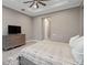 This cozy bedroom features wood flooring, a ceiling fan, and a closet door for convenience at 209 Pine Lilly Ct, Lake Alfred, FL 33850