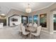 Dining room with large windows and sliding doors to patio and pool with elegant chandelier at 209 Pine Lilly Ct, Lake Alfred, FL 33850