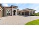 Beautiful front exterior showcasing the paved driveway and attached three car garage at 209 Pine Lilly Ct, Lake Alfred, FL 33850