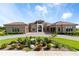 Stunning front exterior of this home with manicured landscaping and paver driveway at 209 Pine Lilly Ct, Lake Alfred, FL 33850