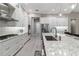 Modern kitchen with white cabinets, stainless steel appliances, and a large center island with seating at 209 Pine Lilly Ct, Lake Alfred, FL 33850