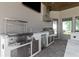 Outdoor kitchen features stainless steel appliances, including a grill, sink, refrigerator, and ice maker at 209 Pine Lilly Ct, Lake Alfred, FL 33850