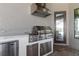 Outdoor kitchen features a built-in grill with stainless steel hood, mini fridge, and marble countertops at 209 Pine Lilly Ct, Lake Alfred, FL 33850