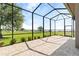 Screened-in patio with a view of the well-maintained lawn and surrounding greenery at 209 Pine Lilly Ct, Lake Alfred, FL 33850