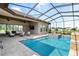 Inviting screened-in pool area with outdoor seating, spa, and serene backyard views at 209 Pine Lilly Ct, Lake Alfred, FL 33850
