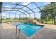Sparkling screened-in pool area with a spa, waterfall feature, and beautifully landscaped surroundings at 209 Pine Lilly Ct, Lake Alfred, FL 33850