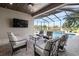 Screened-in pool area with comfortable seating, outdoor kitchen, and scenic views at 209 Pine Lilly Ct, Lake Alfred, FL 33850