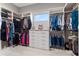 Well-organized walk-in closet features custom shelving, hanging rods, drawers, and a small window for natural light at 209 Pine Lilly Ct, Lake Alfred, FL 33850