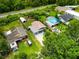 This aerial view showcases the property's location within a quiet neighborhood with mature trees and a nearby railway at 2480 Avenue E Sw, Winter Haven, FL 33880
