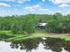 Scenic aerial of a lakeside log home surrounded by lush trees and featuring a private dock at 2530 Arbuckle Shores Rd, Frostproof, FL 33843