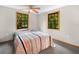 Well-lit bedroom with a ceiling fan, two windows, and neutral-toned carpet at 2530 Arbuckle Shores Rd, Frostproof, FL 33843