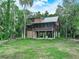 Charming log cabin on stilts, boasting a screened porch and nestled within a verdant, treed lot at 2530 Arbuckle Shores Rd, Frostproof, FL 33843