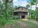 Beautiful raised log home with a lower level carport, surrounded by lush trees and landscape at 2530 Arbuckle Shores Rd, Frostproof, FL 33843
