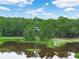 Gorgeous exterior view of a house surrounded by lush greenery and a tranquil lake, showing the scenic setting at 2530 Arbuckle Shores Rd, Frostproof, FL 33843